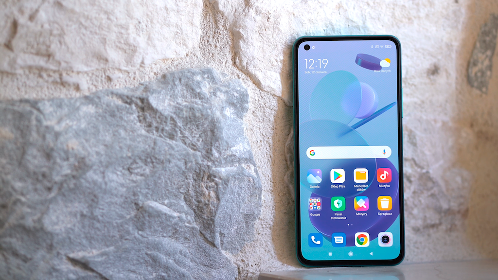 MI 11 Lite 5G smartphone showcasing display and apps against a stone background, ideal travel companion by Xiaomi.