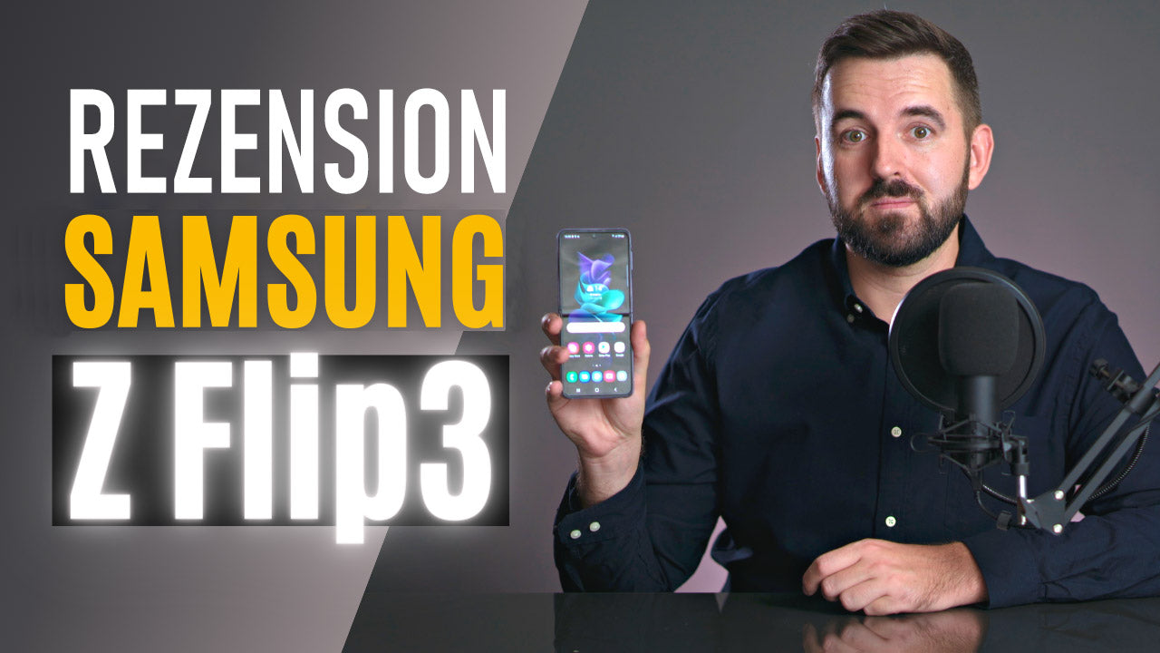Person conducting Samsung Z Flip 3 review holding phone, with microphone, highlighting features and drawbacks.