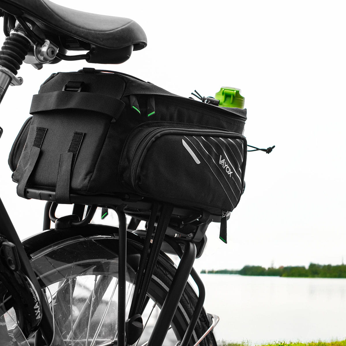 Vayox VA0171 black bike pannier bag on rear rack with water bottle, adjustable 12L capacity, durable nylon and polyester material.