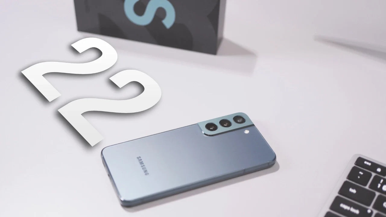 Samsung Galaxy S22 smartphone on a desk with S22 box and laptop in the background, highlighting design and features.