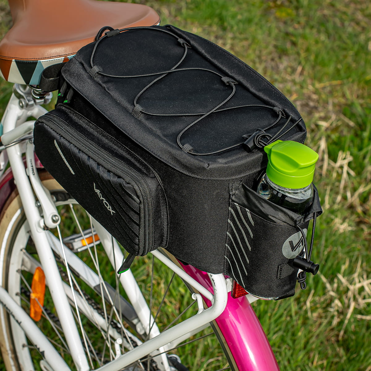Fahrradtasche Vayox VA0171 in Schwarz am Gepäckträger eines Fahrrads, 12L Kapazität, mit Flaschenhalter und robustem Design.