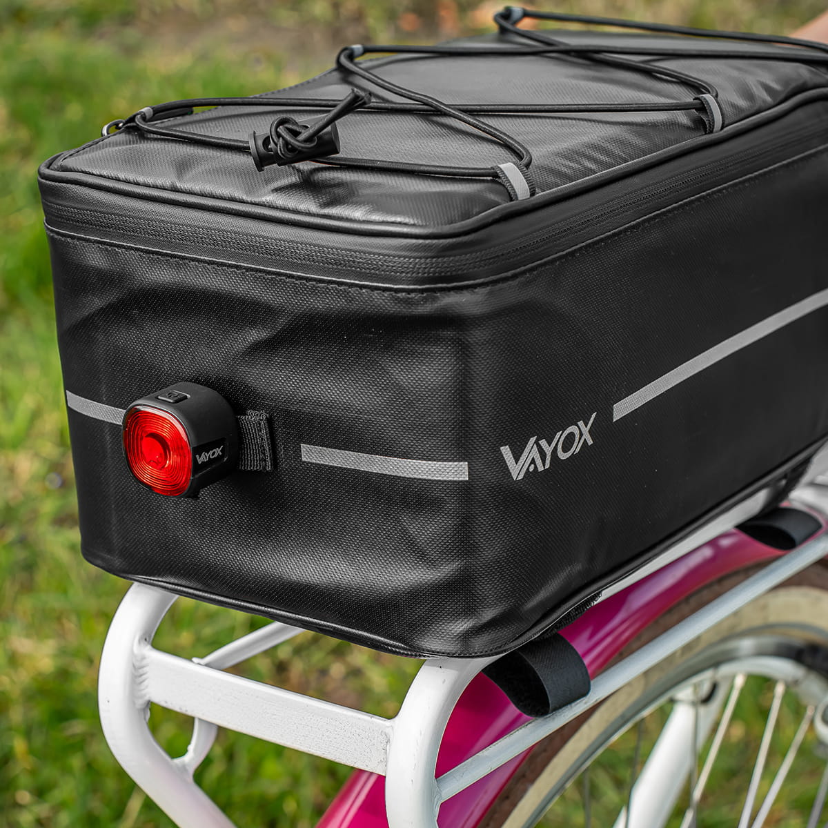 Black Vayox VA0166 8L bike rack bag on a bicycle, featuring durable material and secure attachment with strong Velcro straps.