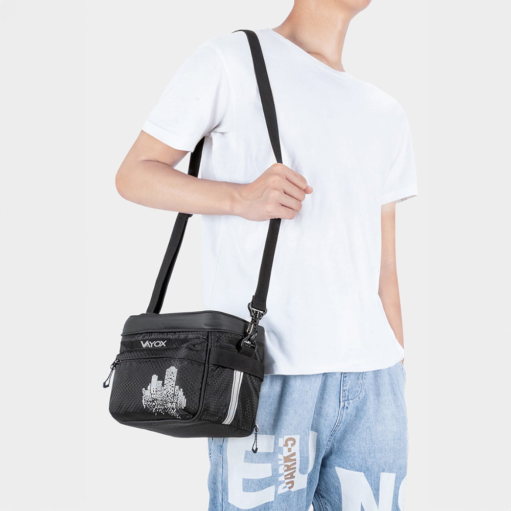 Person wearing Vayox VA0167 black thermal handlebar bag with shoulder strap, showcasing its design and functionality.