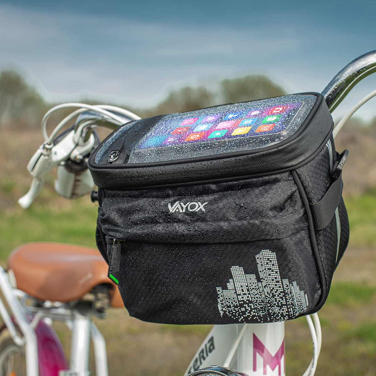 Vayox VA0167 4.6L black insulated handlebar bag mounted on a bicycle, showcasing smartphone compartment, ideal for snacks and drinks.