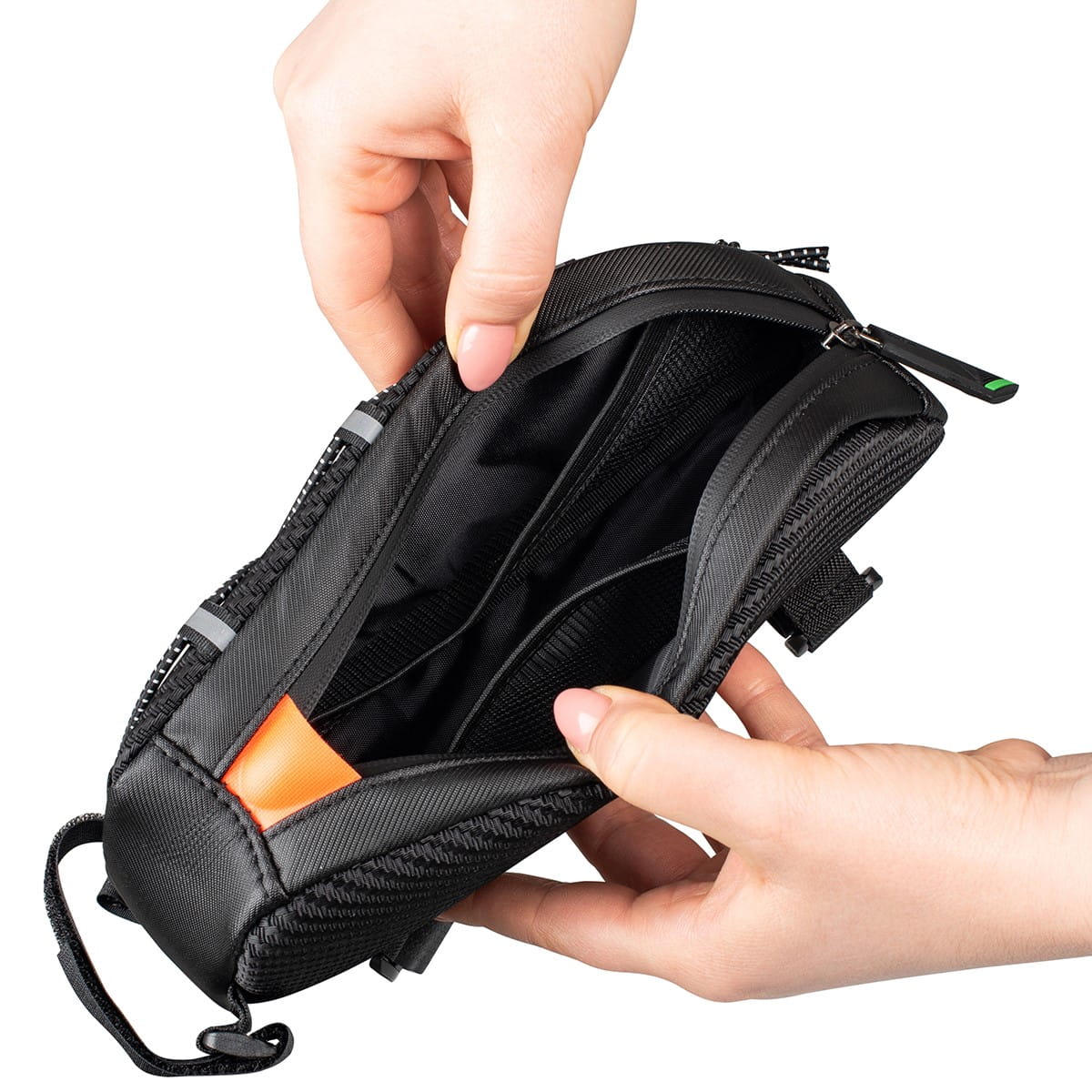 Close-up of someone opening a black Vayox VA0347 1L bicycle frame bag, showcasing the interior space and compartments.