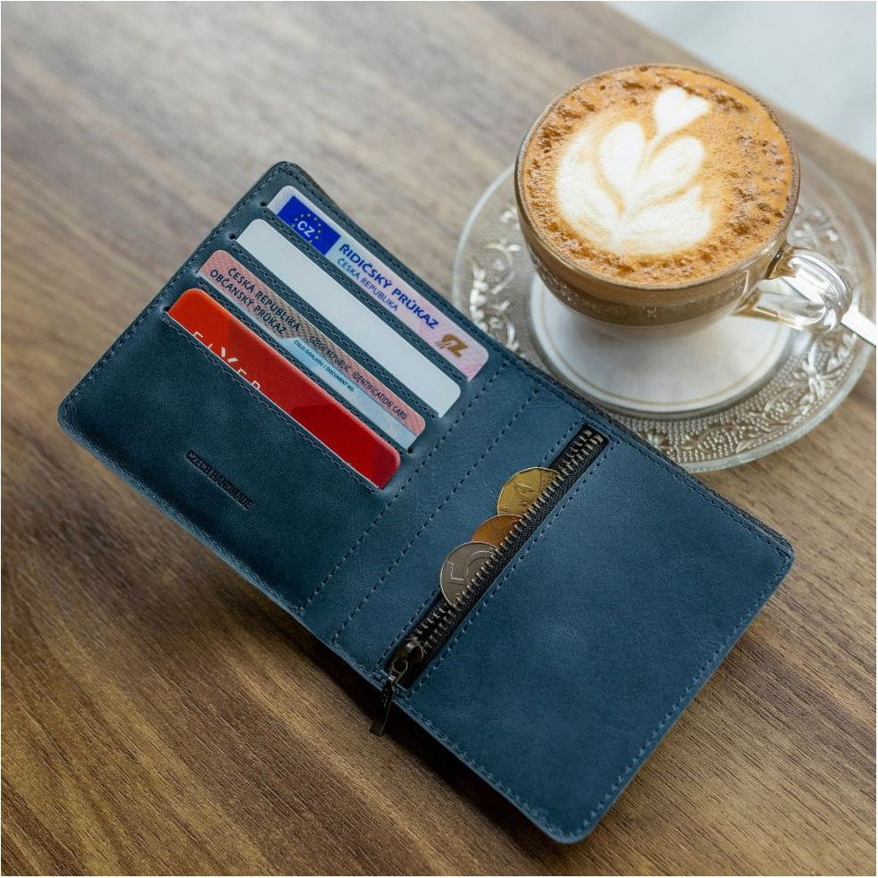 Elegante blaue Brieftasche mit Kreditkartenfächern und Kaffee auf Holztisch