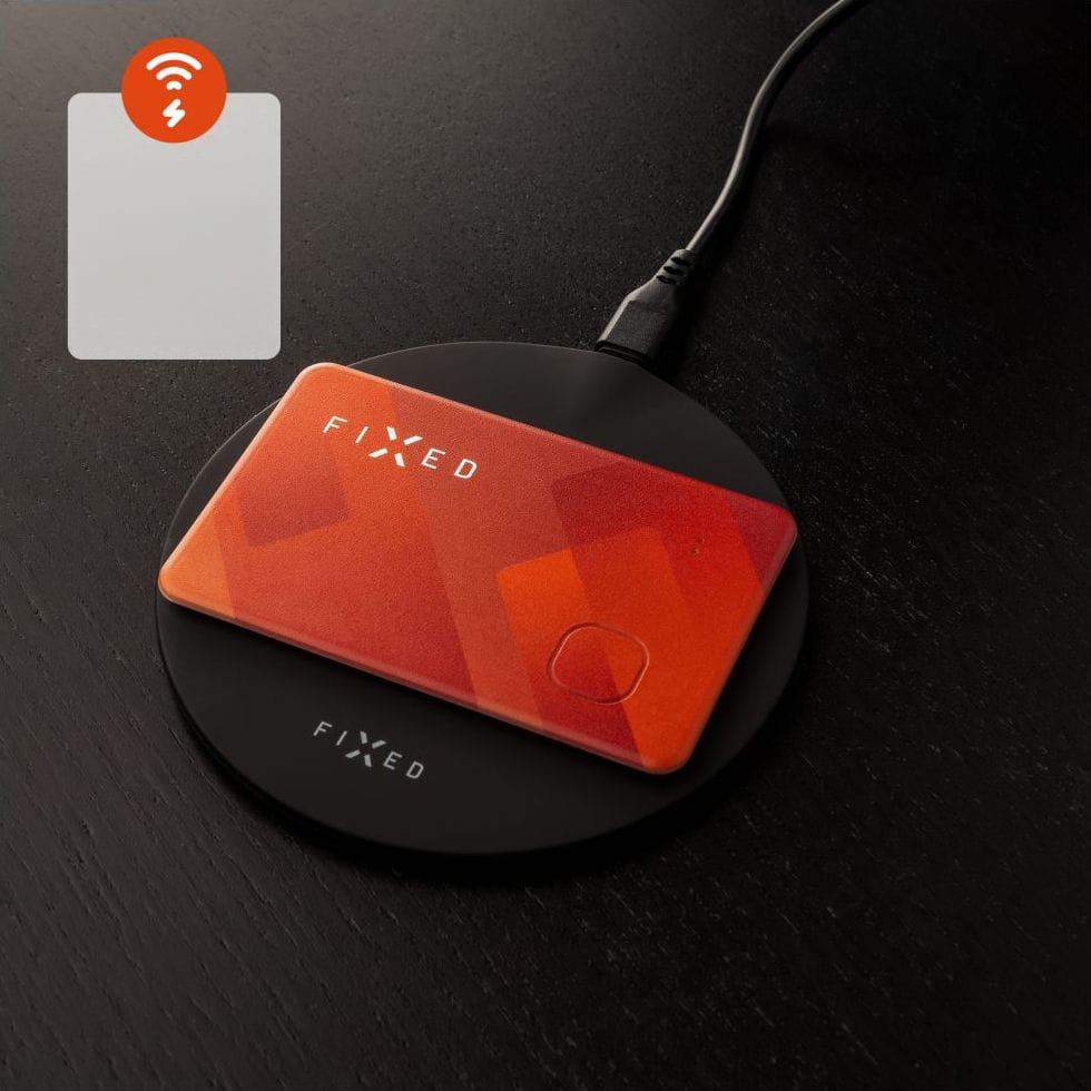 Der orange FIXED Tag Card Bluetooth-Tracker auf einer Ladestation, kompatibel mit Apple-Geräten und der "Find My"-Funktion.