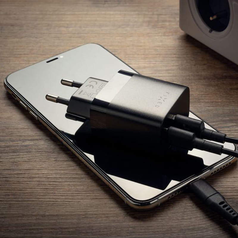 Schwarzes Ladegerät Fixed Travel Charger auf Smartphone, USB-C/USB-A, kompakte mobile Aufladungslösung mit 20W Leistung.